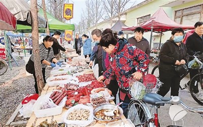 市民在北京市海淀区上庄水乡大集上购买食品。苏明辰摄