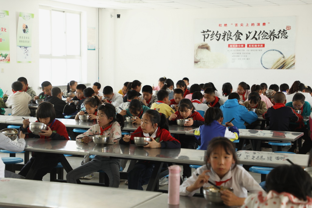 5月17日，学生在甘肃省平凉市崆峒区寨子街中心小学食堂用餐。